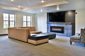 Fireplace lounge next to the Community Room with a large TV for a movie night.